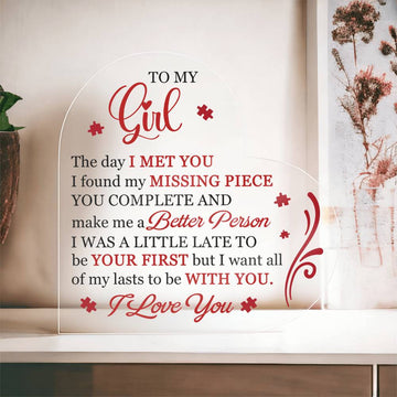 A heart-shaped acrylic plaque with a printed message for a girlfriend, featuring red text and decorative elements.