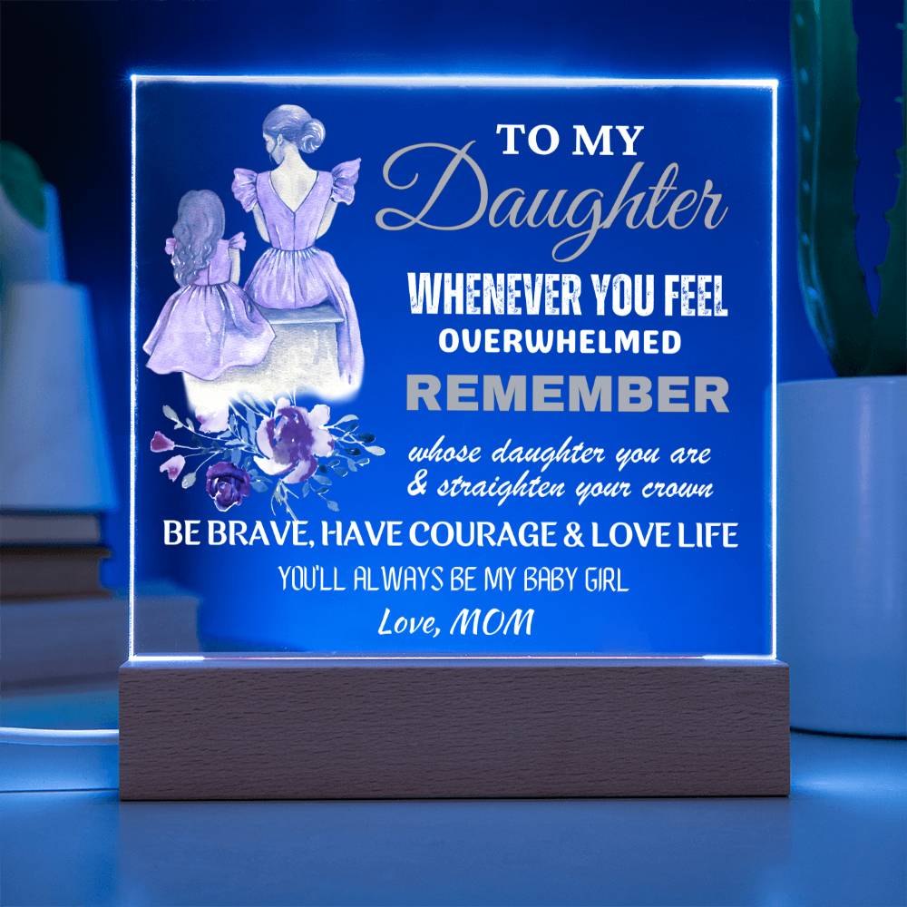 An engraved acrylic keepsake with built-in LED lights displaying a message to a daughter from her mom, placed on a wooden base.