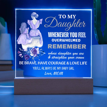 An engraved acrylic keepsake with built-in LED lights displaying a message to a daughter from her mom, placed on a wooden base.