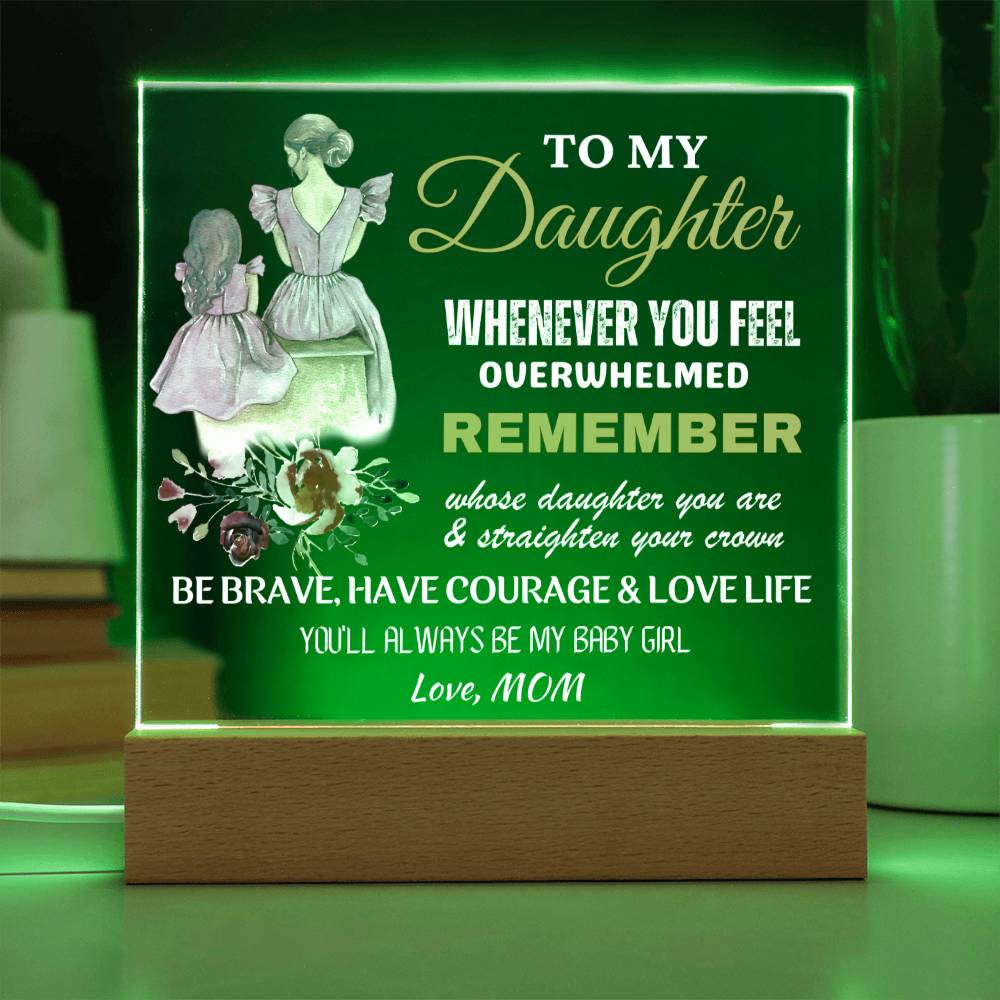 An engraved acrylic keepsake with built-in LED lights displaying a message to a daughter from her mom, placed on a wooden base.