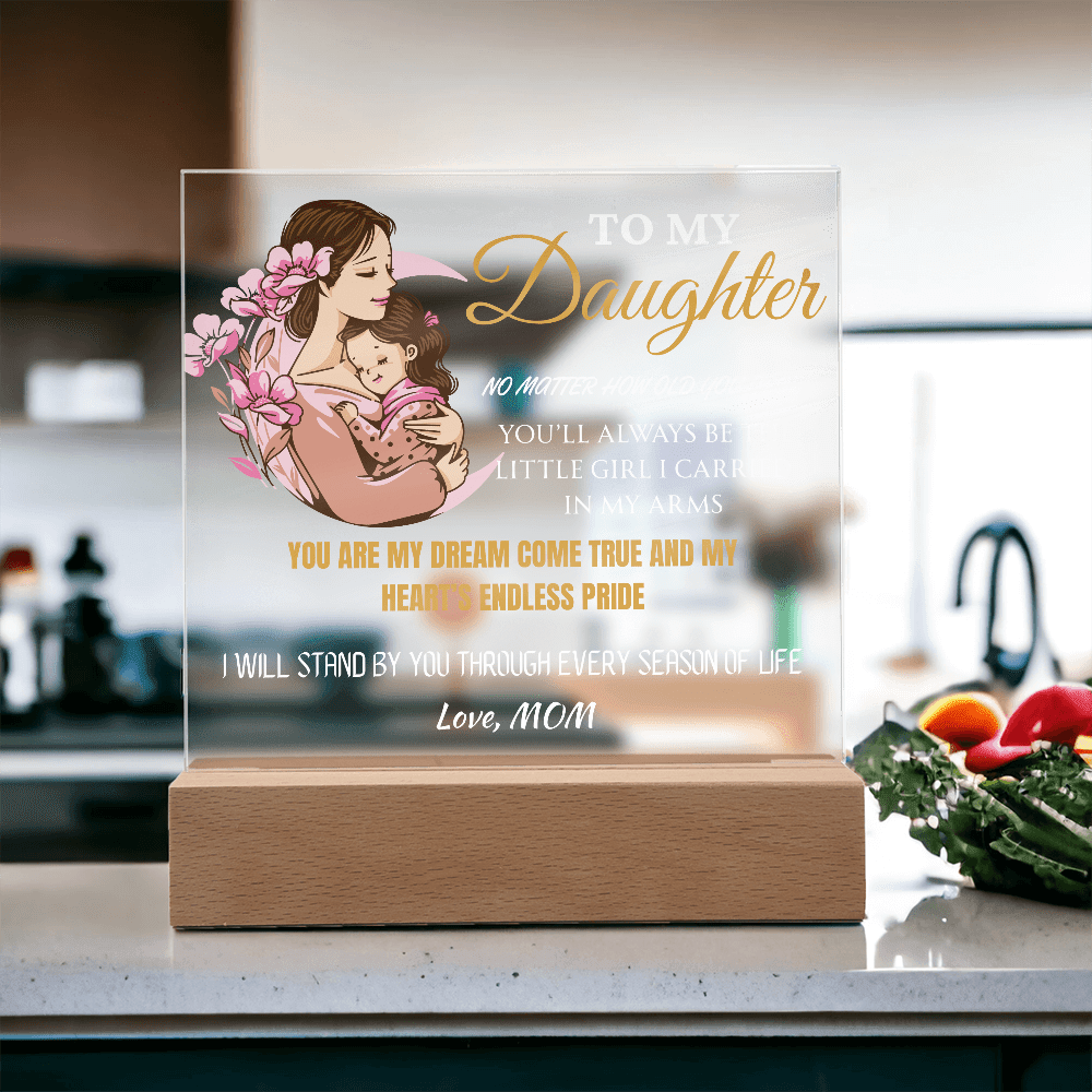 Acrylic plaque with a mother and daughter illustration and sentimental text on a kitchen counter.
