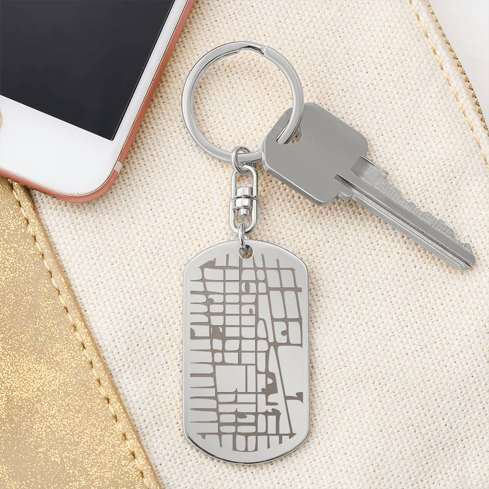 Keychain with map design attached to a key and phone on a beige surface
